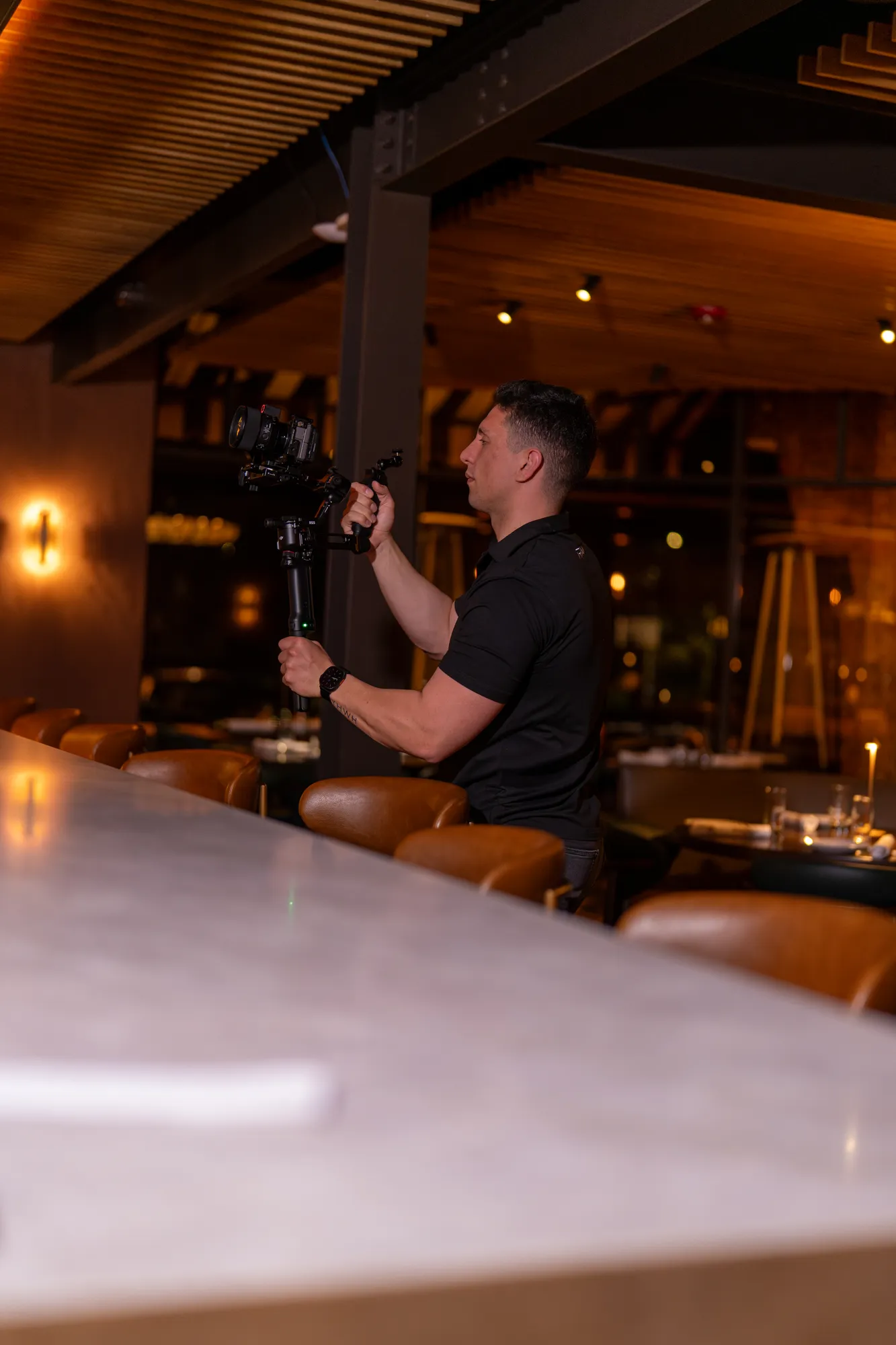 Videographer filming with a gimbal rig inside a restaurant