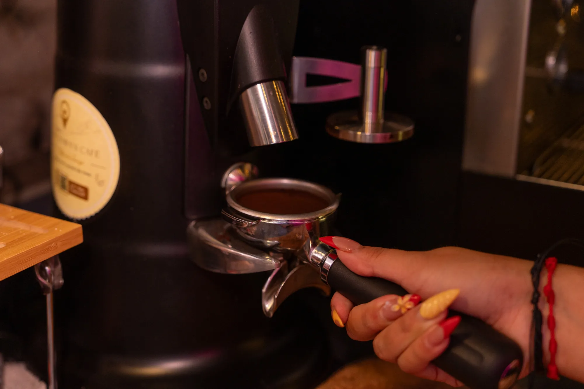 Espresso grounds being dosed into a portafilter at a coffee bar
